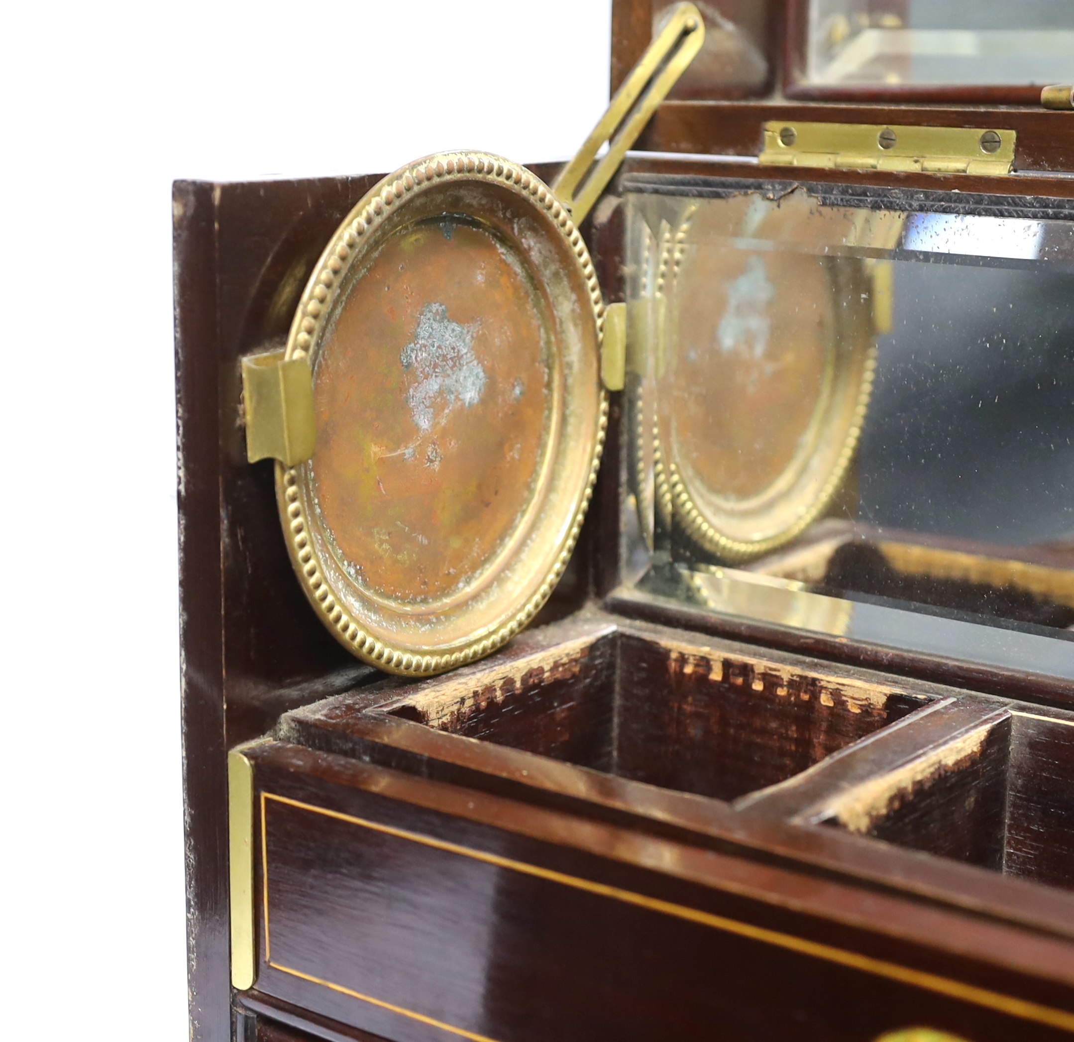 An Edwardian Sheraton revival inlaid mahogany portable drinks cabinet with tantalus and other accessories including serving trays, a brass cribbage board, with secret drawer, etc, 37cm high